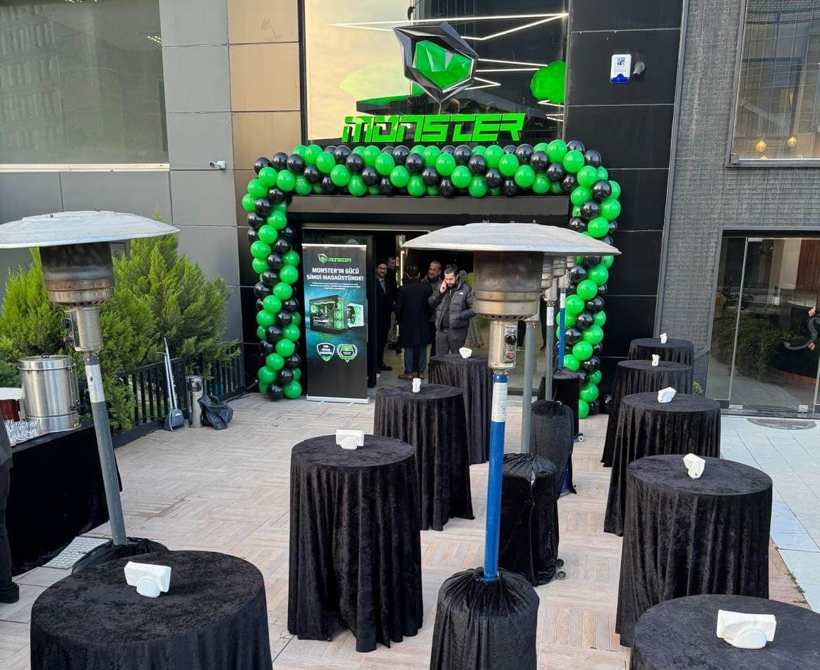 Canlı ve renkli zincir balon süslemeleri ile dikkat çekici hale getirilen bir mağaza açılışının dış cephesi, kurdele kesimi için hazır bir kalabalığı gösteriyor.