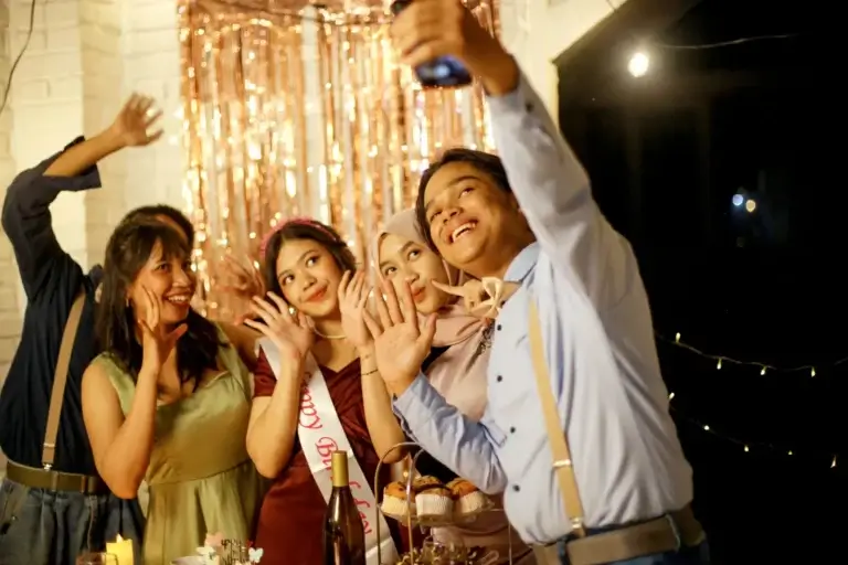 Bir kurumsal etkinlikte, katılımcıların etkileşim halinde olduğu, modern bir sahne düzeni ve ışıklandırma.