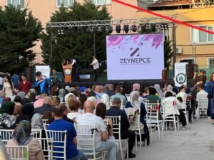 Bursa'da Zeynepce Ajans tarafından düzenlenen açık hava etkinliği, sahnede konuşmacılar, LED ekranda Zeynepce logosu ve oturan kalabalık bir davetli topluluğu. Profesyonel Bursa organizasyon şirketi.
